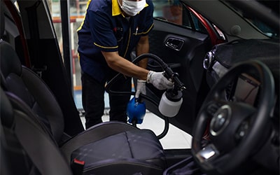 Attendant treating a car interior