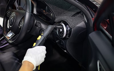 Vacuum cleaning a car footwell